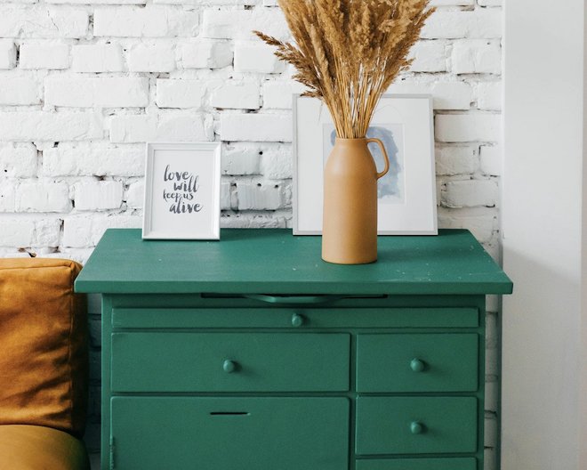 dark green drawers in front of white wall